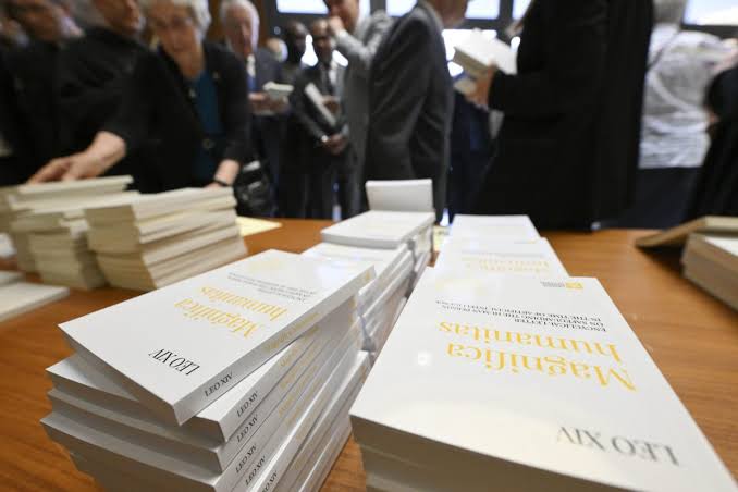 A capitalist (priest) reads ‘Magnifica Humanitas’