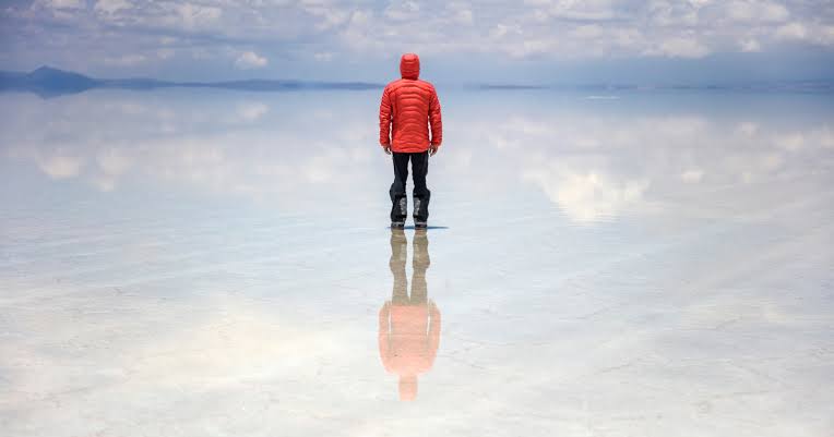 In the middle of the rainy season, a stretch of Bolivia's high desert turns into the largest mirror on the planet — a thin, perfectly still sheet of water spread across ten thousand square kilometers of salt, so exact that the sky and the ground become impossible to te