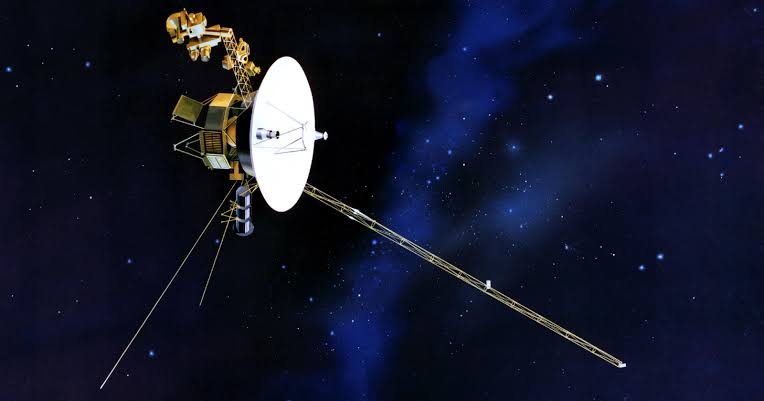 Voyager 1 has no engine running. The 38,000-mile-per-hour speed it has held since its Saturn flyby in 1980 is borrowed momentum from planets it grazed more than four decades ago, and that free ride carries it to one light-day from Earth this November