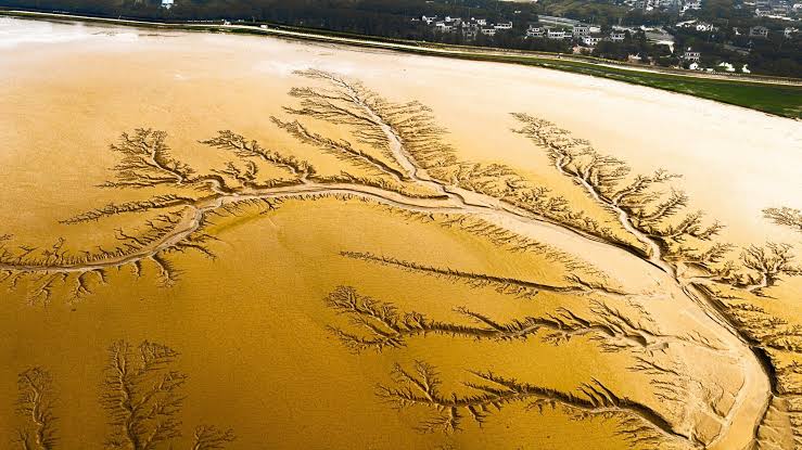 How does a moon 1.4 billion kilometres from the Sun end up with rivers, rain and lakes, but not a single drop of water in any of them?