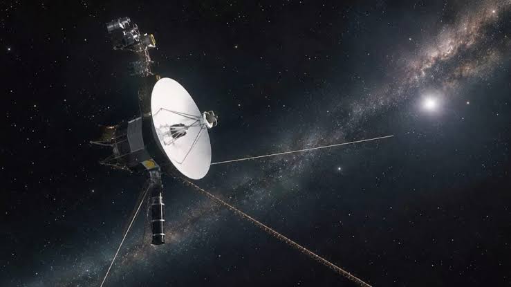 Voyager 1 launched in 1977 on a four-year mission and is still flying 49 years later, now so far away that in November 2026 a radio signal will take a full 24 hours to reach it — so when engineers say "good morning" on a Monday, the answer won't arrive until