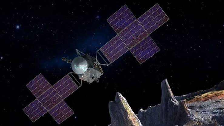 Asteroid 16 Psyche, a metal-rich world roughly 225 kilometres wide orbiting between Mars and Jupiter, may contain extraordinary amounts of iron and nickel — enough that back-of-the-envelope estimates have put its theoretical metal value at around $10,000