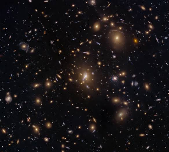 Hubble captures galaxy swarm with lensed arcs from early universe