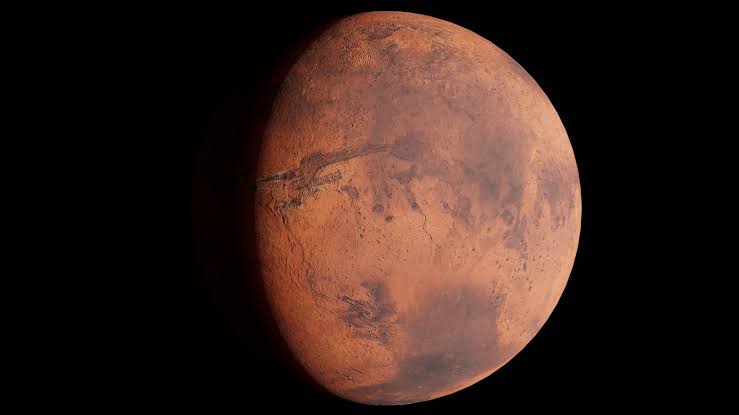 The tallest volcano in the solar system is so wide that from most places on its slopes, you would never see a dramatic summit rising ahead of you — Olympus Mons is broader than some countries, and its gentle flanks curve away with Mars long before the mou
